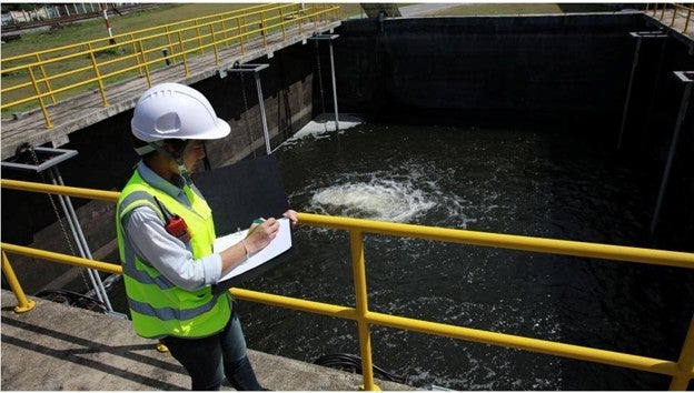 Image of worker with clipboard at wastewater facility